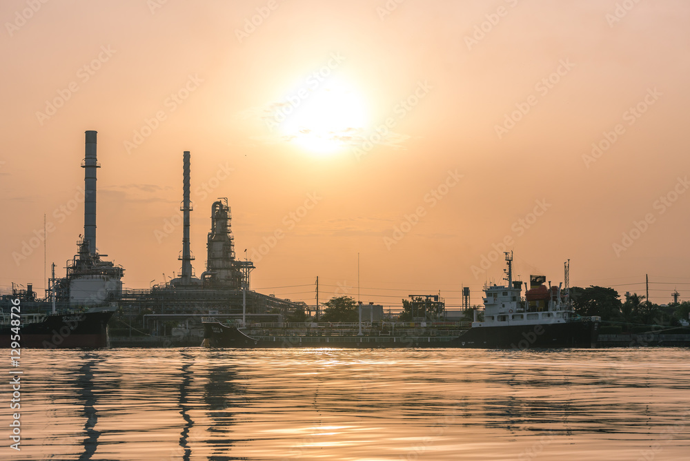 Big gold sun over the oil refinery.