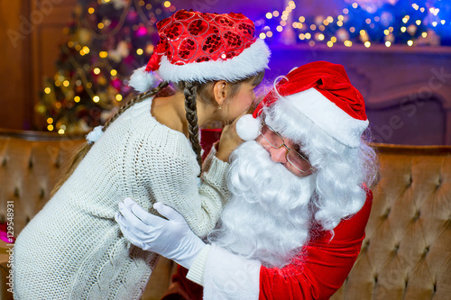 Santa Claus and lettle girl with Christmas gifts photo