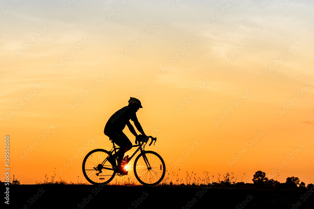 Obraz premium Silhouette of cyclist motion on sunset background