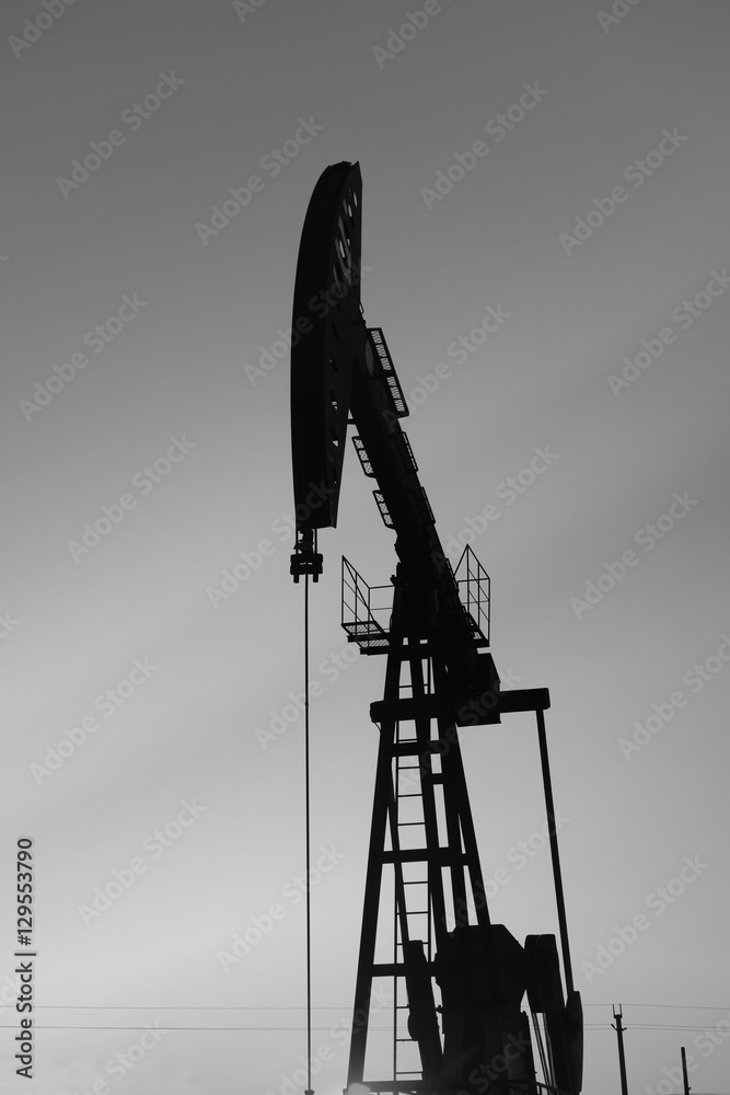 Obraz premium The beam pumping unit is homework, sunset in oil field