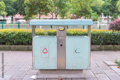 trash cans in the park beside walkway