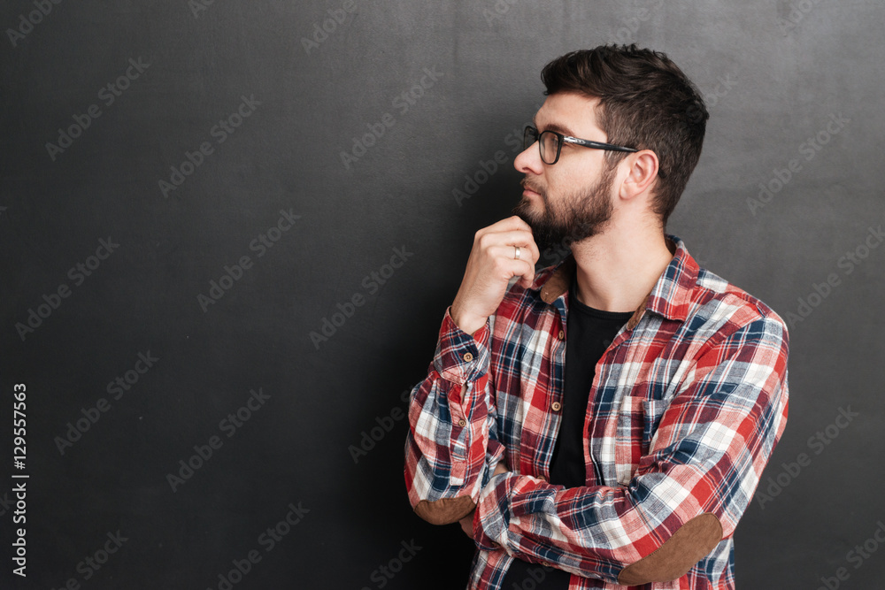 Pensive bearded young man thinking and looking away