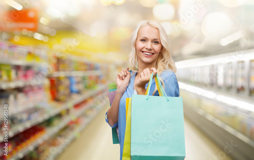 happy woman with shopping bags at supermarket