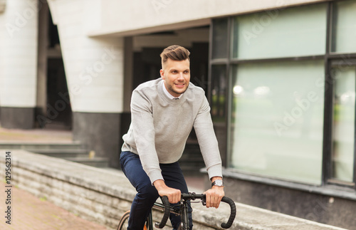 young man riding bicycle on city street