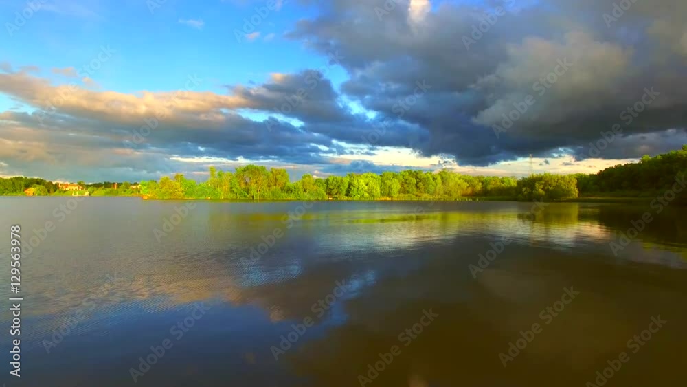 Sunlit peninsula under dramatic sky, gliding over the water, aerial view.
Sunlit peninsula under dramatic sky, gliding over the water, aerial view.