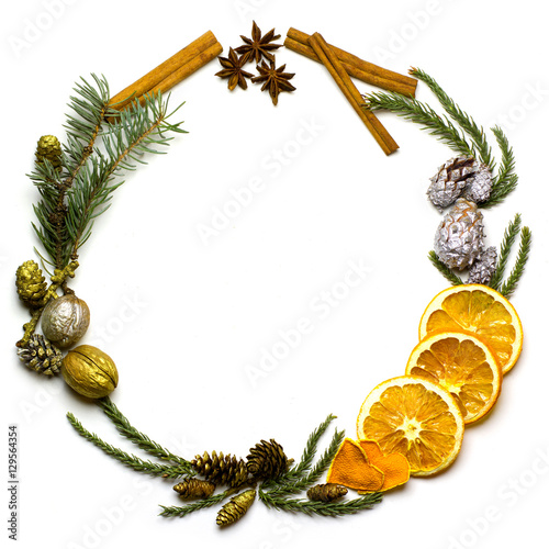 Fototapeta Naklejka Na Ścianę i Meble -  Christmas round frame made of natural winter things, fir tree branch, golden and silver pine cones, walnuts, cinnamon. star anise, dry oranges fruit. Flat lay. New Year`s background isolated on white.