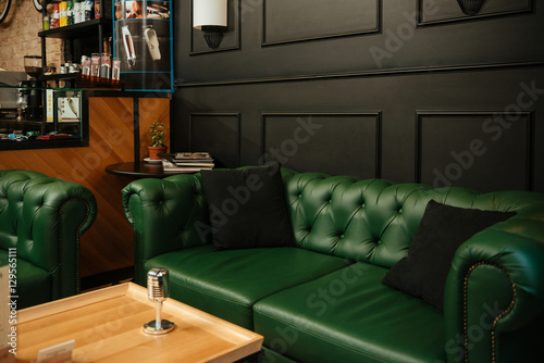 Microphone on table against restaurant background with sofa