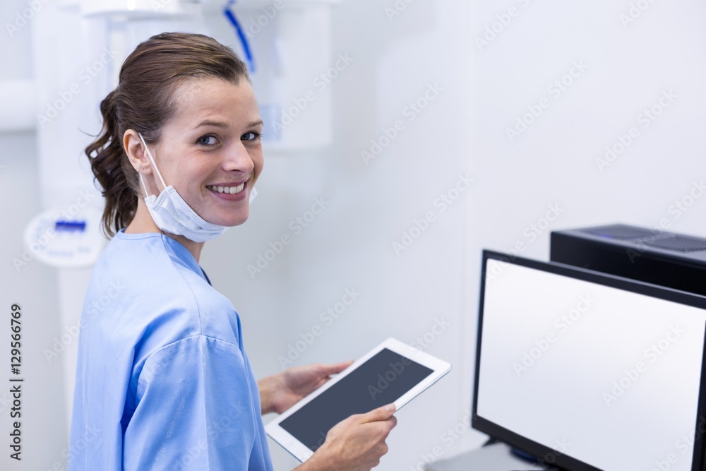 Smiling dental assistant holding digital tablet Smiling dental assistant holding digital tablet