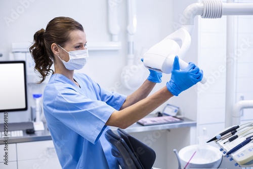 Dental assistant adjusting light