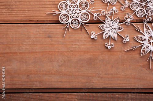 Paper snowflakes made with quilling technique on a wooden surfac