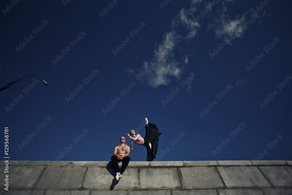 young woman and a man performing gymnastic exercises against the young woman and a man performing gymnastic exercises against the