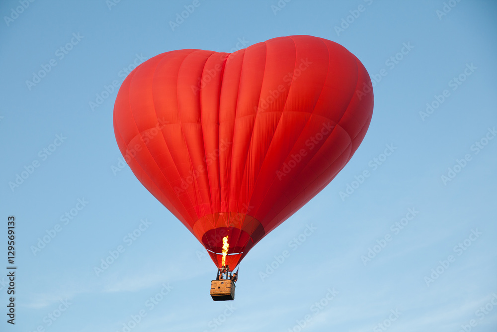 Naklejka Heart shaped balloon. A journey for lovers. Aerostat against the blue sky.