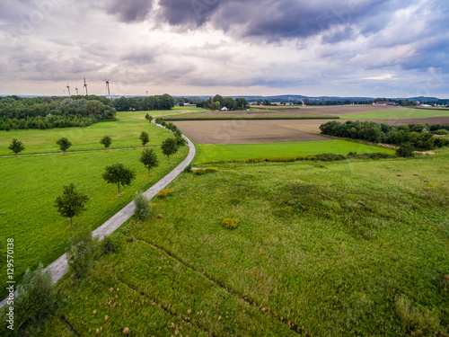 Luftbild - Felder und Wiesen mit Weg und Windkraft
