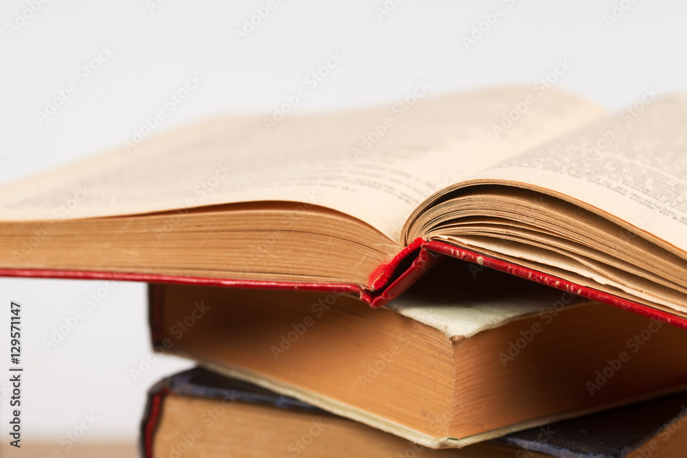 Naklejka premium Open book, stack of hardback books. Back to school.