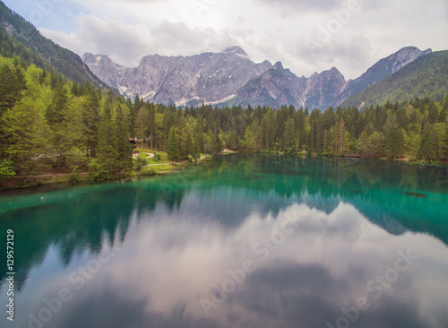 Fototapeta Naklejka Na Ścianę i Meble -  Aerial: Beautiful Mountain Lake Landscape With Panoramic View Of Mountain Alps On Background