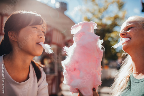 Two young women sharing cotton candyfloss photo