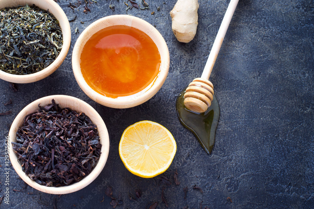 Fototapeta premium Wooden bowl with a dry tea and fresh honey, lemon and ginger. To