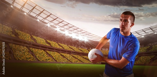 Composite image of rugby player looking away while holding ball 