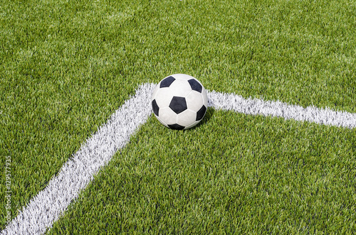 The soccer football on the white line in the artificial green grass field © tkroot