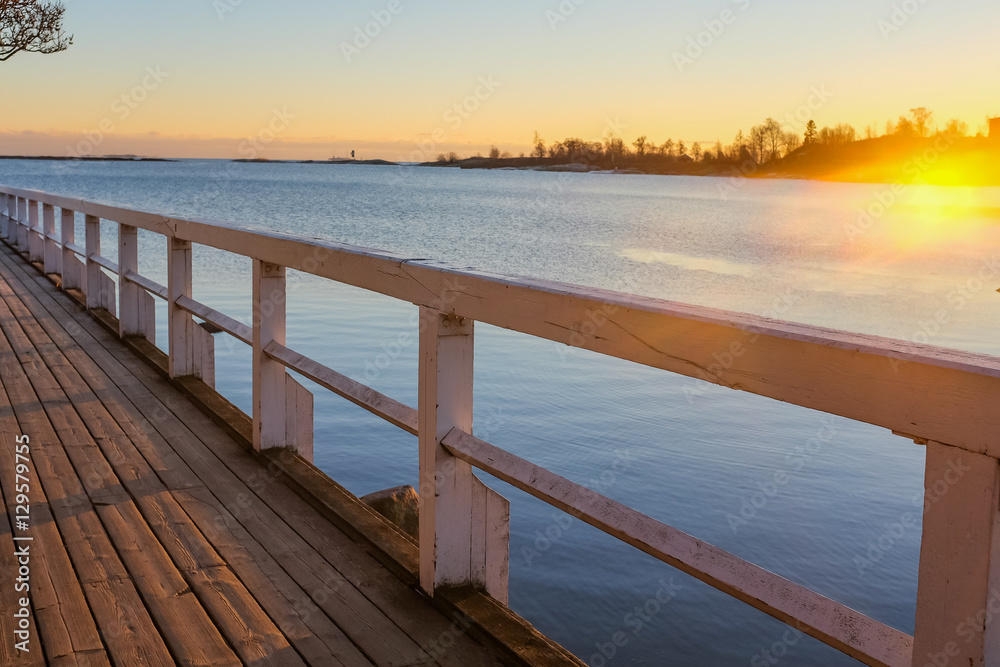 Fototapeta premium Wooden footbridge to sea at sunset. Kaivopuisto park, Helsinki, Finland.