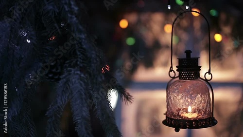 A vintage lantern with a candle on a background of Christmas lights
