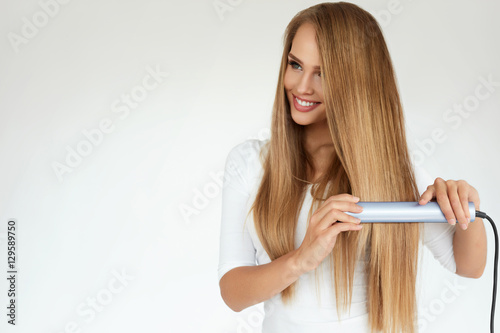 Beautiful Woman Ironing Long Straight Hair With Straightener