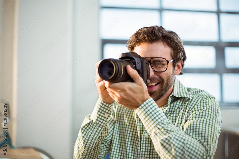 Graphic designer clicking photo from digital camera Graphic designer clicking photo from digital camera