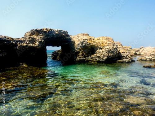 Arco naturale di roccia sul mare turchese nell'isola di Kos Grecia © poldina