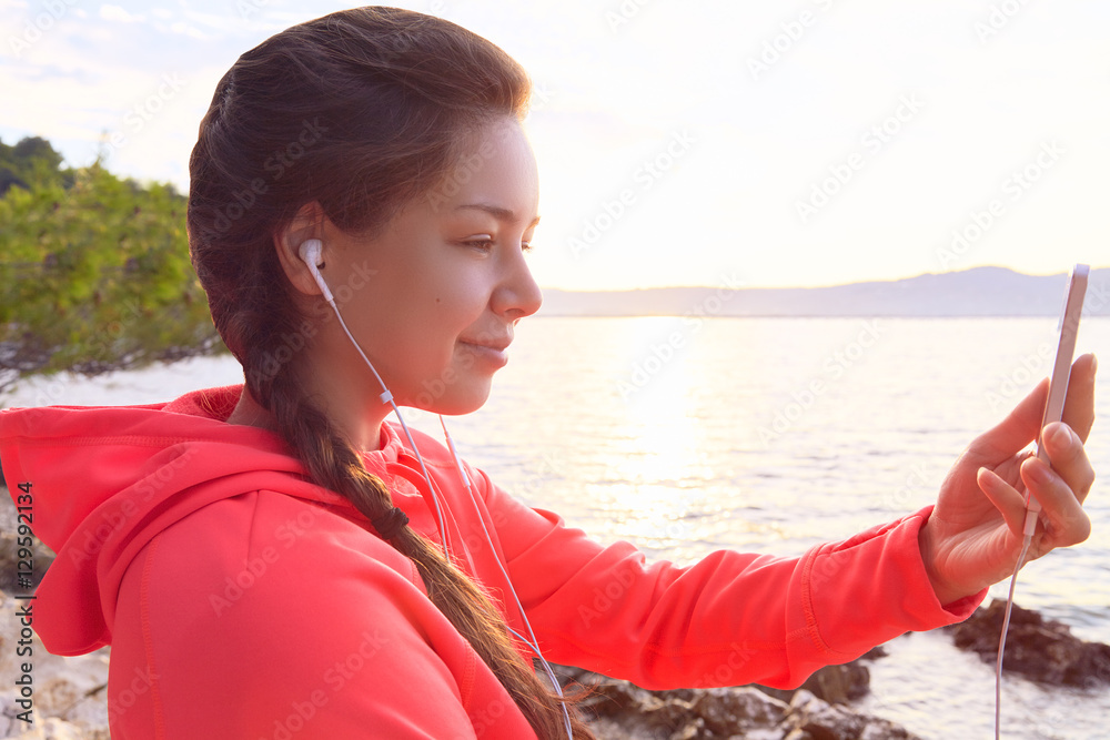 Young woman making selfie at rock beach after run Young woman making selfie at rock beach after run