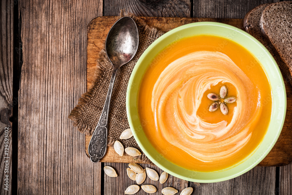 Pumpkin soup on rustic wooden background Pumpkin soup on rustic wooden background