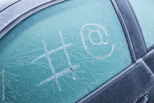 Hash and at sign, drawn on a frozen car window.