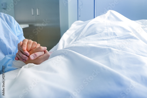 Фотография Wife holds the hand of the deceased spouse in the hospital