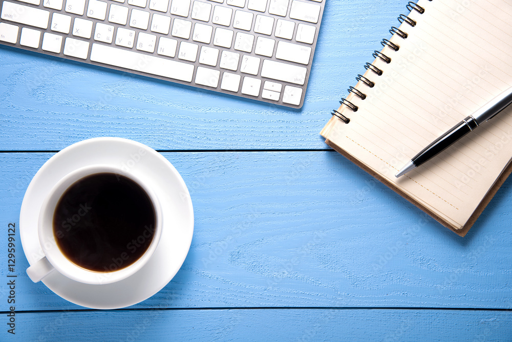 office supplies and cup of coffee on blue wooden table. top view office supplies and cup of coffee on blue wooden table. top view