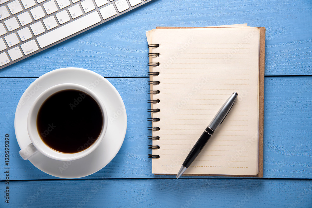 Wood table with office supplies and cup of coffee, top view Wood table with office supplies and cup of coffee, top view