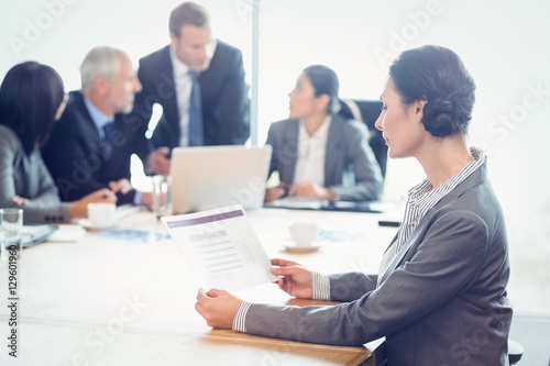 Side view of businesswoman reading report