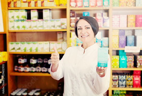 Woman in white coat promoting food additive goods in carton in d