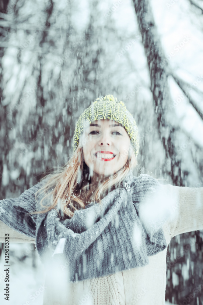 Beautiful girl fun outdoor in winter forest under snowflakes. holding a snow. winter scene people magic.