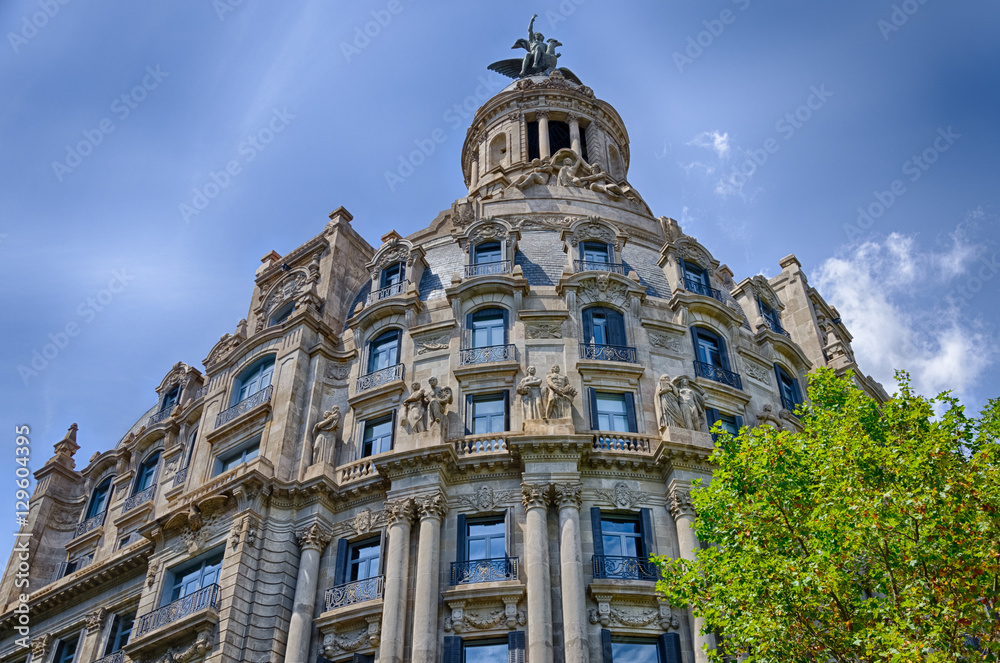 Fototapeta premium Interesting facade with statues on blue sky background in Barcelona, Spain