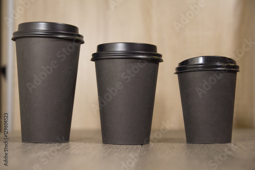 three paper Cup of black coffee on wooden background