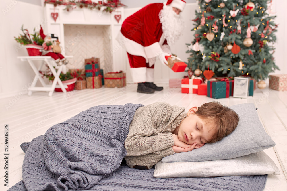 Santa Claus leaves a presents while child sleeps