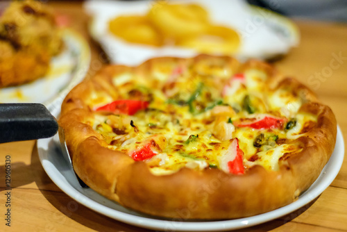 Seafood Italian Pizza slice on wood table in fastfood restaurant