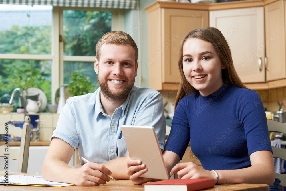 Male Home Tutor Helping Teenage Girl With Studies