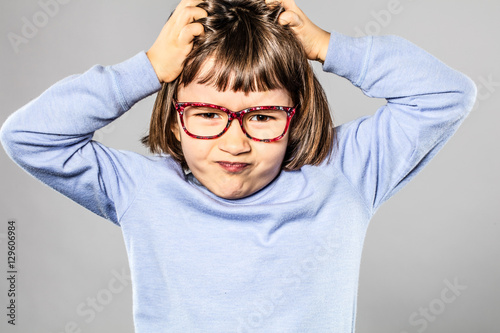 annoyed child scratching head for small tantrum or itchy allergies