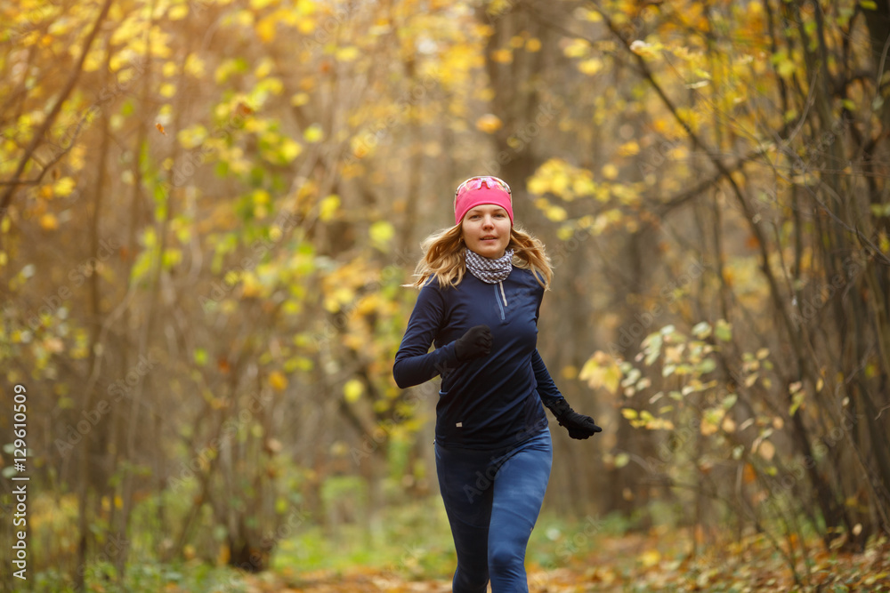 Woman running among autumn leaves