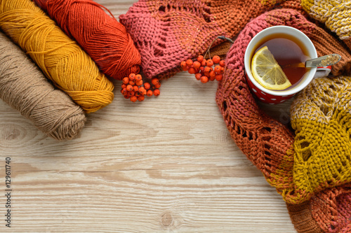 Cake, tea, mountain ash, a thread for knitting on a wooden table