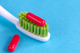 concept toothache with toothbrush and pills at blue background