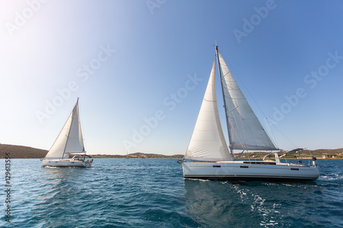 Luxury yachts at regatta. Sailing in the wind through the waves at the Aegean Sea.