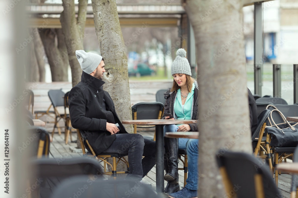 © bokan - Group of students or young business people is sitting in an outdoor café on a cold winter day.