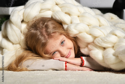 Young preety girl lying near under big handmade merino wool blan photo