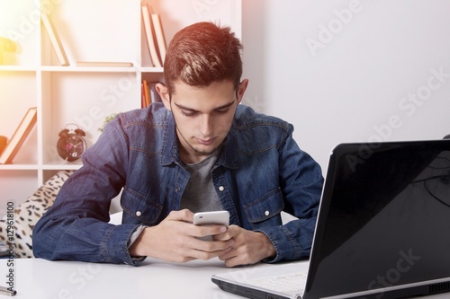 studying or young businessman smiling with the phone mobile and the PC laptop in house photo